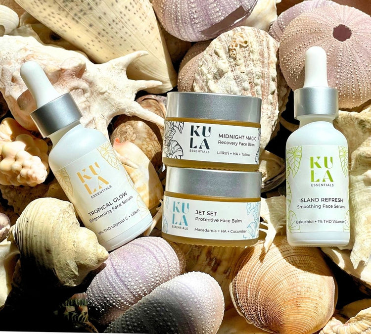 Kula Essentials face serums and balms on seashells and coral