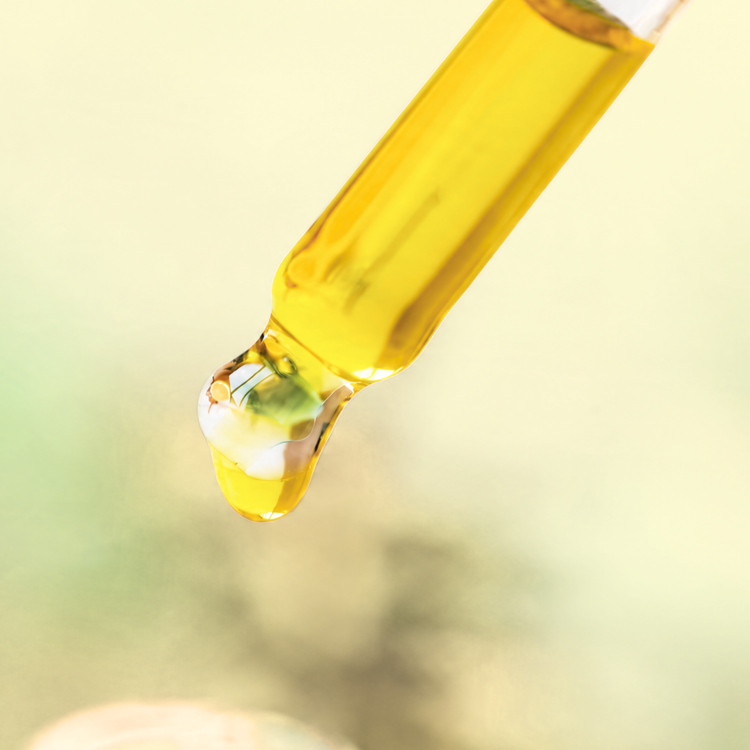 Tropical Glow Brightening Serum drop from a glass dropper